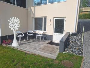 a wooden deck with a table and chairs next to a building at Apartment Songhill in Kuopio