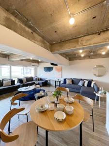 a living room with a wooden table and chairs at b hotel Dai3Himawari - Amazing Dome View 30 sec PeacePark, Up to 10 ppl in Hiroshima