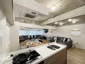 a kitchen and living room with a couch and a table at b hotel Dai3Himawari - Amazing Dome View 30 sec PeacePark, Up to 10 ppl in Hiroshima +19 photos