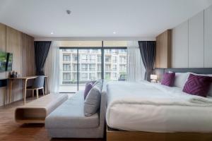 a hotel room with a large bed and a couch at Pool View Wyndham Condo 1310 in Nai Thon Beach +30 photos