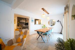 una sala da pranzo e un soggiorno con tavolo e sedie di L'Onde calme, charmante villa avec piscine a Saint-Laurent-de-la-Salanque