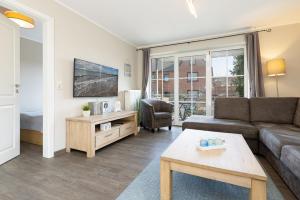 a living room with a couch and a table at Bellevue 02 in Laboe