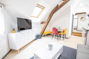 a living room with a tv and a table at Au cœur d'Amboise - Garage privé 2 roues in Amboise