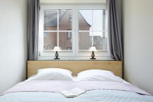 a bedroom with a bed with two lamps and a window at Bellevue 02 in Laboe