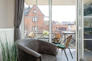 a living room with a chair and a table and a balcony at Bellevue 02 in Laboe +33 photos
