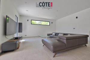 Una sala de estar con un sofá y un televisor de pantalla plana. en Villa Marisol, en Carry-le-Rouet