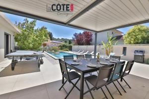 Un patio con mesa y sillas y una piscina. en Villa Marisol, en Carry-le-Rouet 11 fotos más