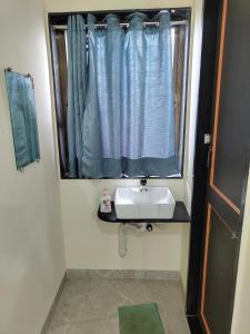 a bathroom with a sink and a window at Shikhar camping bhandardara in Bhandāra