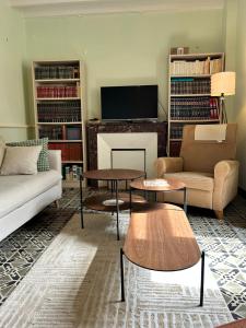 Maison de famille au cœur du bocage normand في Besneville: غرفة معيشة مع أريكة وطاولات وتلفزيون +63 صورة