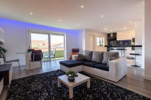 Una sala de estar con un sofá y una cocina. en Lucky House (A L), en Praia de Esmoriz