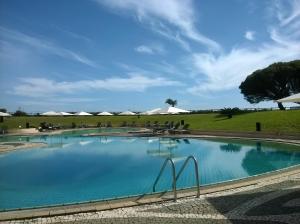 a large swimming pool with chairs and umbrellas at Pestana Bahia Praia Nature & Beach Resort in Vila Franca do Campo