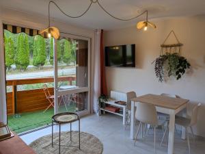 a dining room with a table and a window at Face au lac avec parking, proche commerces in Savines