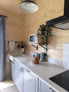 eine Küche mit weißen Arbeitsflächen und Holzwänden in der Unterkunft Cabaña de madera Mar y Madera, playa de las catedrales in Barreiros