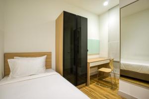 a small bedroom with a bed and a desk at RYO Shaftsbury Putrajaya in Putrajaya