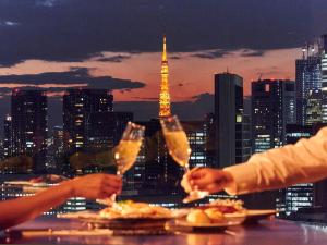 two people holding wine glasses in front of a city skyline at Ginza Creston in Tokyo