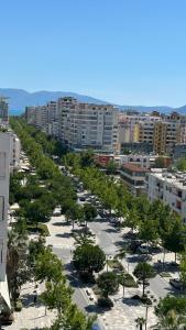 una calle bordeada de árboles en una ciudad en Aura Vlore, en Vlorë