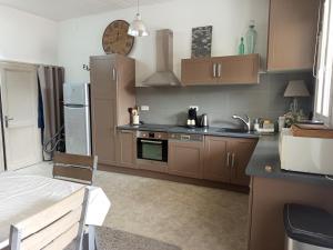 a kitchen with brown cabinets and a sink and refrigerator at T2 avec terrasse - Centre de Langon in Langon
