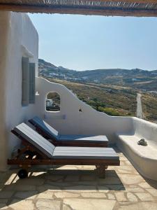 a balcony with two beds and a tub on a building at Blue and White Mykonos ap2 in Mikonos