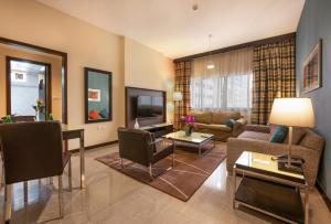 a living room with a couch and a tv at The Eclipse Boutique Suites in Abu Dhabi
