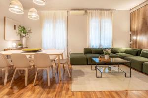 a living room with a table and a green couch at Sagrada familia Secret Apartment in Barcelona