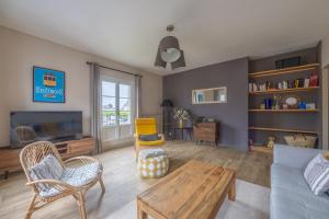 a living room with a couch and a table at Le Soleil de Saint Patrice in Bayeux