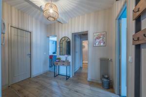 a hallway with a door and a table and a mirror at Le Soleil de Saint Patrice in Bayeux +5 photos