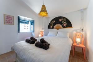 a bedroom with a large white bed with two black cats on it at House in the center of Tossa de Mar in Tossa de Mar