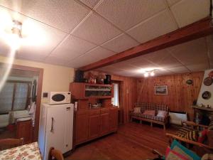 a kitchen with a white refrigerator and wooden cabinets at Limpida Brezza in Prali