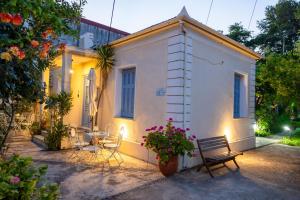 ein kleines weißes Haus mit einem Tisch und Stühlen in der Unterkunft Faros - Drosostalides, Milina in Milína