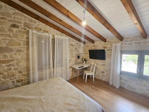 a bedroom with a bed and a desk and a television at Gem apartment Analipsi in Hersonissos