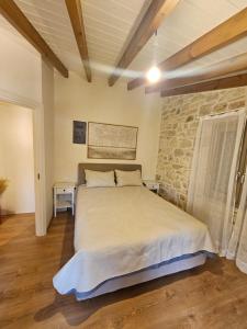 a bedroom with a bed and a stone wall at Gem apartment Analipsi in Hersonissos