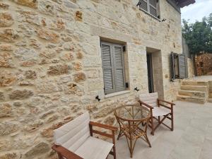 a patio with chairs and a table and a building at Gem apartment Analipsi in Hersonissos