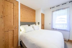 a bedroom with a large white bed and a window at SmartStay - Super Morzine in Morzine
