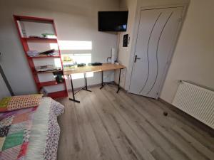 a room with a desk and a bed and a table at Chambres Logement 130m2 - Circuit 24h Le Mans in Arnage