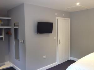 una camera da letto con TV a schermo piatto a parete di Woodland Waters a Ancaster