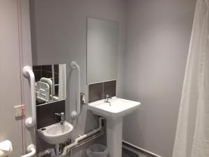 La salle de bains blanche est pourvue d'un lavabo et d'un miroir. dans l'établissement Woodland Waters, à Ancaster
