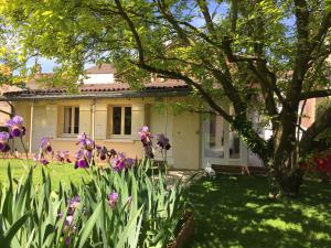 una casa con flores púrpuras en el patio en Hôtel Concorde, en Mâcon