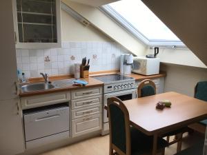 a small kitchen with a sink and a table at Ferienwohnung Am Kanadablick in Stützengrün