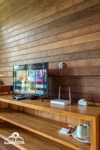 a flat screen tv sitting on top of a wooden shelf at Pondok Nini Bungalow by Bukit Vista in Ubud