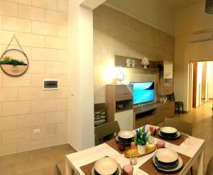 a living room with a table and a tv at Il Pumo Salentino in Lecce