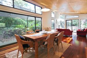 ein Esszimmer mit einem Holztisch und Stühlen in der Unterkunft Hyams Retreat Hyams Beach in Hyams Beach + 12 Fotos