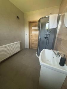 a bathroom with a sink and a shower at Zielona Osada Apartamenty in Ciężkowice +16 photos