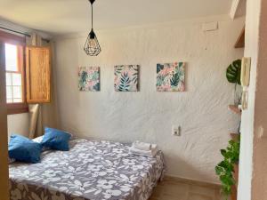 a bedroom with a bed and paintings on the wall at Estudio en el Castillo de Denia in Denia