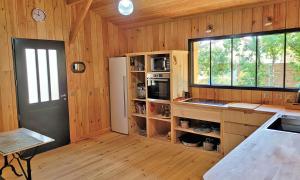 eine Küche mit Holzwänden, einem Fenster und einer Theke in der Unterkunft Villa Naïade, Lège-Cap-Ferret, Arcachon Bay in Lège-Cap-Ferret