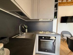 eine Küche mit Spüle und Herd oberen Backofen in der Unterkunft Appartamento di Celsa in Abbadia San Salvatore
