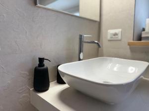 ein weißes Waschbecken in einem Badezimmer mit einem Spiegel in der Unterkunft Appartamento di Celsa in Abbadia San Salvatore