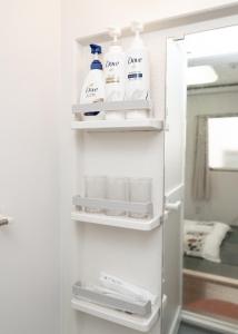 Un refrigerador blanco con estantes en un baño. en 匯金芝浦ビル, en Tokio