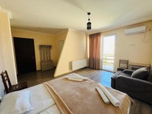 a living room with a bed and a couch at Guest House Sanapiro in Telavi