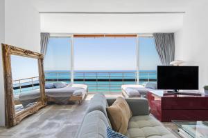 a living room with a couch and a mirror at Casa Sol - Impresionantes vistas al mar in Torremolinos