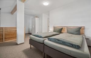 two beds in a bedroom with white walls at 1 Bedroom Nice Apartment In Oberhof in Oberhof +4 photos